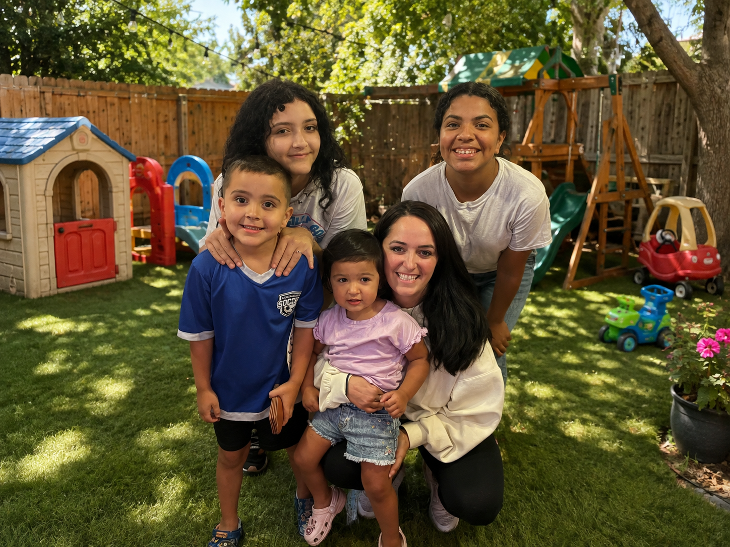 Caregivers and children together in the sunny backyard play area